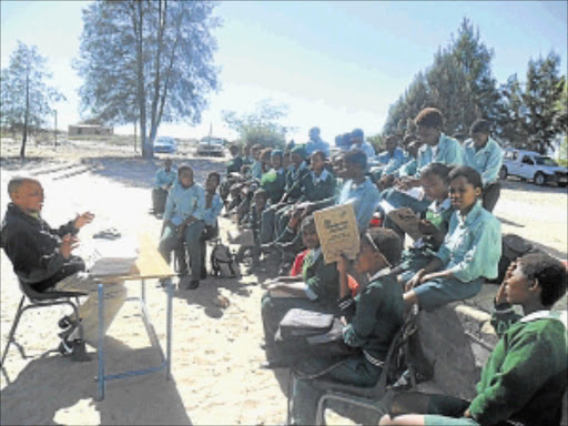 CAUGHT IN-BETWEEN: Tlotlang Thuto Middle School pupils learn under the trees after protesters burnt their school. Photos: Boitumelo Tshehle
