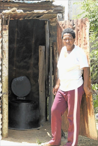 SLOW REMOVALS: A resident of Monyakeng, Wesselsbron in Free State, stands next to her bucket system toilet. PHOTO: ANTONIO MUCHAVE