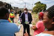 HELP IS AT HAND: Nelson Mandela Bay municipality officials, including human settlements political head  Andile Mfunda, handed out sanitiser, gloves, soap and masks to residents of Area Q in Walmer Township on Tuesday
