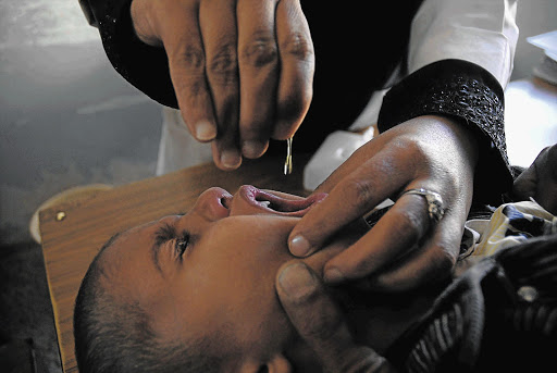A child receives a dose of polio vaccine for children under the age of five.