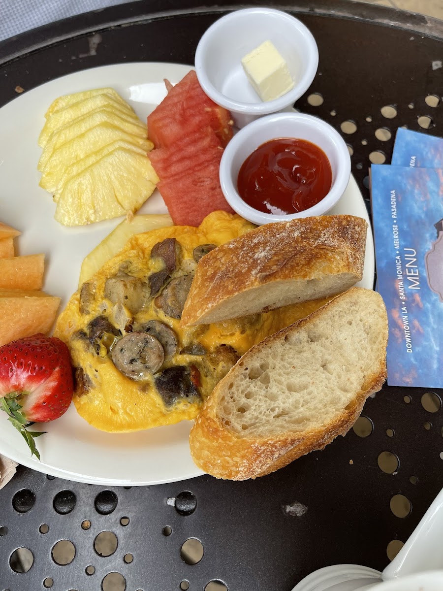 Sausage potato omelet with heirloom tomatoes, fruit and deliocious not gluten free sourdough bread