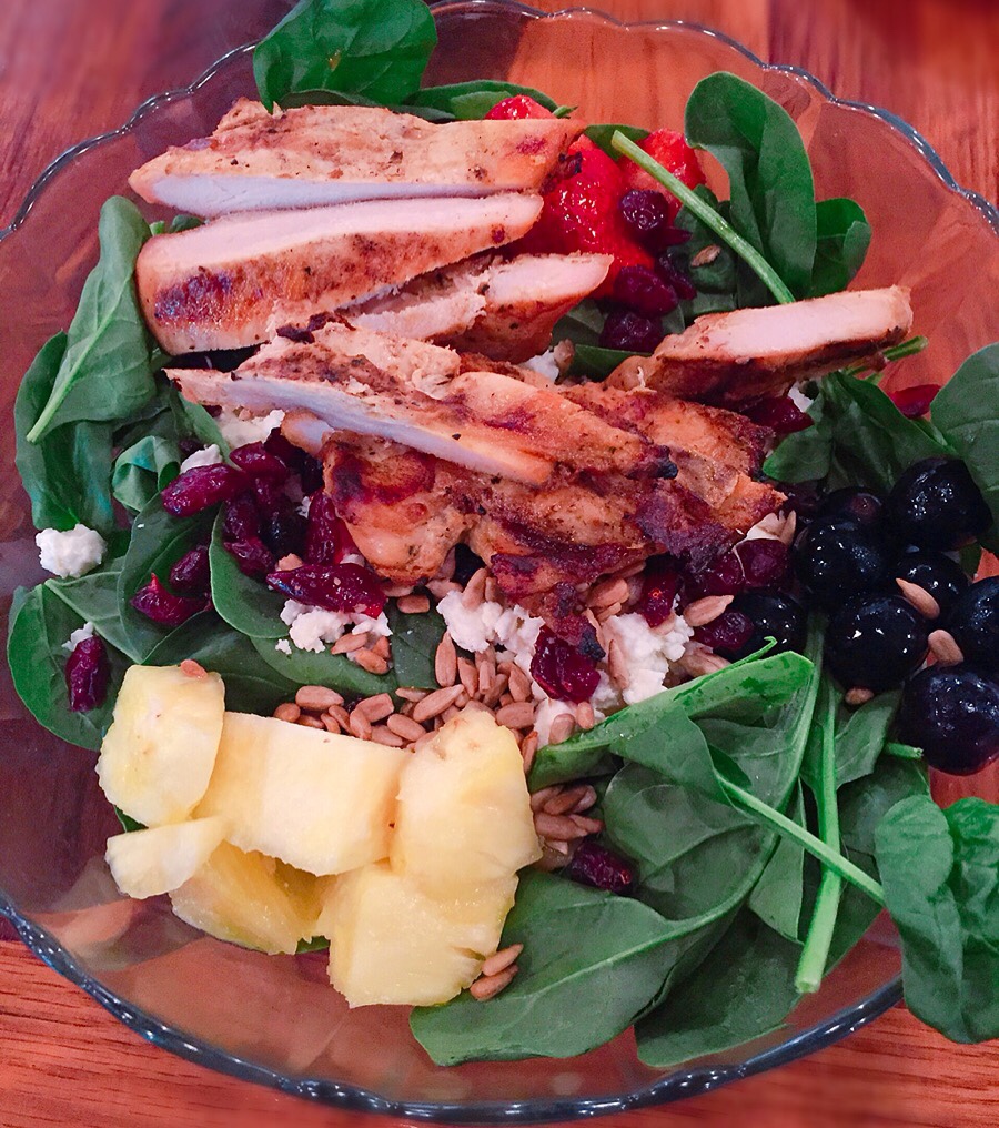Spinach salad w/ pineapple, grapes, strawberries, dried cranberries, feta cheese, & perfectly marinated grilled chicken. Loved it!