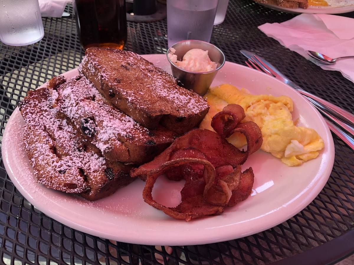 This is the gluten free raisin French toast with an added scrambled eggs and bacon strips.