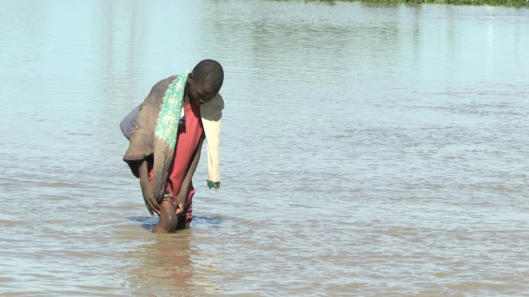 A young boy walks through flooded Ayweyo area in Nyando subcounty on April 16, 2024.