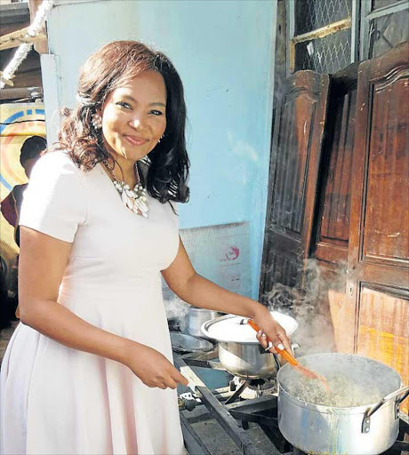 HELPING HANDS: Siba Mtongana, cooking for kids at the launch in Alexandria township Picture: SUPPLIED