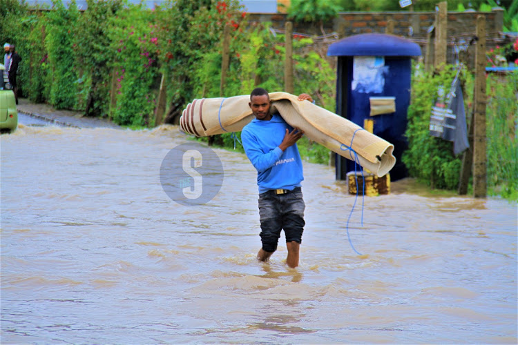 A man walking along the flooded Syokimau - Katani road in Machakos County on Sunday, April 21, 2024.