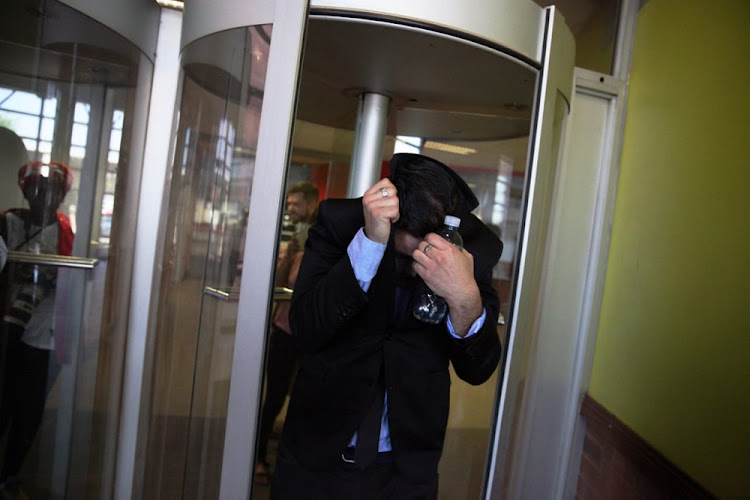 Former Parktown Boys High School water polo coach Colin Rex hides his face after leaving the high court sitting at the Palm Ridge Magistrate’s Court, South of Johannesburg. Rex is facing several charges of sexually assault.