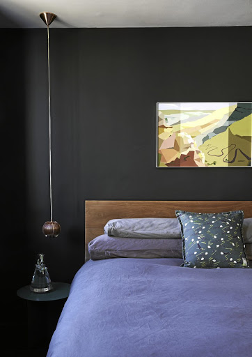 The intense paint colour (Plascon Sushi Wrap) and a statement Tom Dixon copper bronze pendant light give the otherwise simple main bedroom a touch of drama.