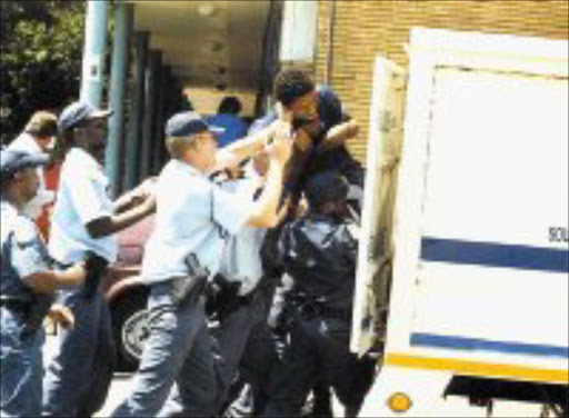 BAD BEHAVIOUR: Protesting students from the Vaal University of Technology are pushed into police vans after they went on the rampage on campus. © Unknown.