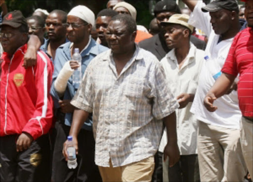 DEFIANT: Morgan Tsvangirai, centre, and other activists outside the court in Harare Zimbabwe. © AP.