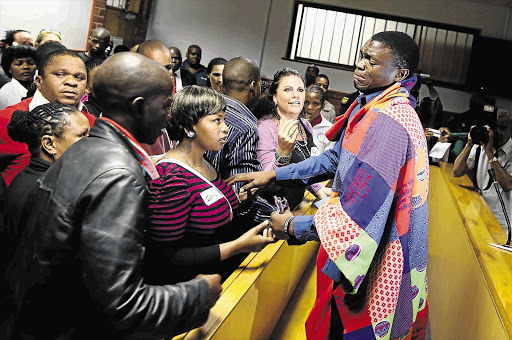 Supporters console truck driver Sanele May in the Pinetown Magistrate's Court. May, wearing a hand-stitched blanket made by a support group member, faces 23 counts of murder in connection with a road accident last year. File Photo