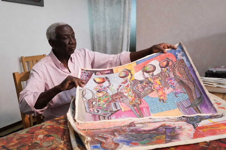 Salah Abdel-Hay Fathallah, a retired Assistant Professor at the Department of Art Education at the University of Kordofan, holds an artwork at his rented house, in Cairo, Egypt May 30, 2023.