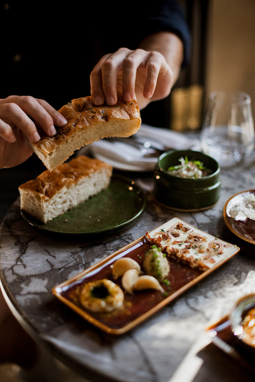 Fresh-out-the-oven bread, cultured butter, olives, whole confit garlic cloves