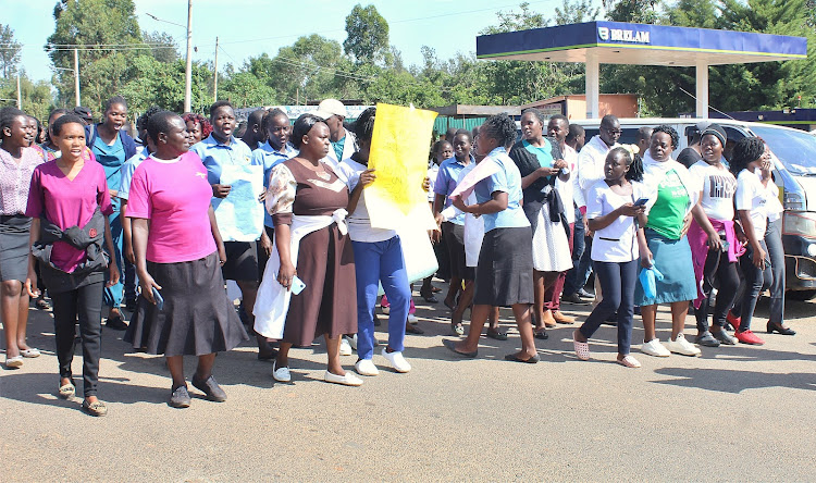 The staff of St. Elizabeth Hospital Mukumu in Kakamega demonstrating at Khayega along Kisumu -Kakamega highway in demand of their over 5 months delayed salaries at the hospital on Monday