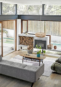 The concrete fireplace is set in a wall of glass blurring the boundaries between indoor and out.