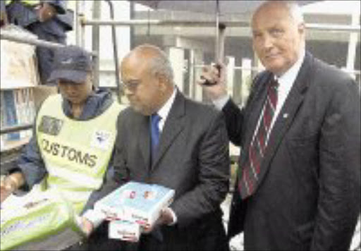 BURNING ISSUE: South African Revenue Service Commissioner Pravin Gordhan checks up on Custom staff at Durban harbour in this file picture. Durban is one of many ports where smuggled cigarettes can leak into South Africa, although it has up-to-date technology to scan shipments for illegal goods. 24/06/2006. © Unknown.