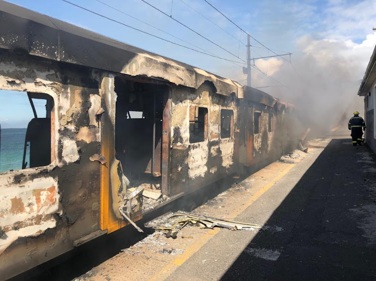 Three train carriages were burning on Monday at Glencairn station in Cape Town.