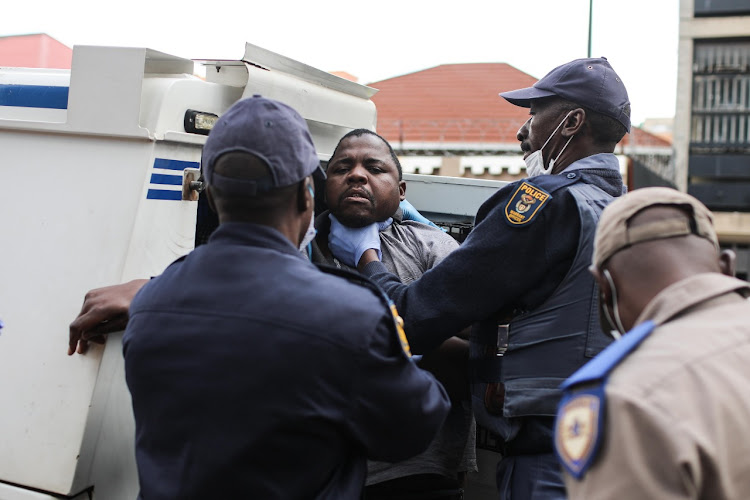 Police load a man into a van during operations on day two of the lockdown in Hillbrow and Yeoville.