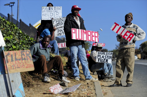 Unemployed painters, plumbers and tilers wait outside Builder's Warehouse in Johannesburg, South Africa, for job opportunities on June 6, 2012.