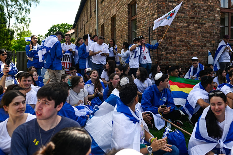 Participants carry Israel’s flag during the 36th March of the Living at the former Nazi concentration death camp Auschwitz I on May 6 2024 in Oswiecim, Poland. The International March of the Living event takes place on Yom HaShoah, where thousands of people from around the world march the three kilometres between the prisoner of war camps, Auschwitz to Birkenau in memory of the holocaust victims of World War 2.