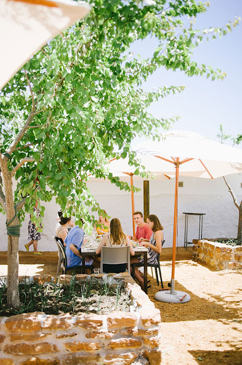 Cream tables in a shaded, stone courtyard – The Kraal has a stark Mediterranean feel.