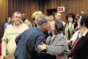 Ina Bonnette, right background, looks on as Johan Kotze is comforted by a supporter after the adjournment of arguments in mitigation of sentence in the Pretoria High Court yesterday. Kotze and three co-accused have been found guilty of the gang rape of Bonnette
