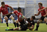 South Africa's Lions wing Anthony Volmink (L) is tackled by Argentina's Jaguares flanker Tomas Lezana (bottom) during their Super Rugby match at Jose Amalfitani stadium in Buenos Aires on March 11, 2017.