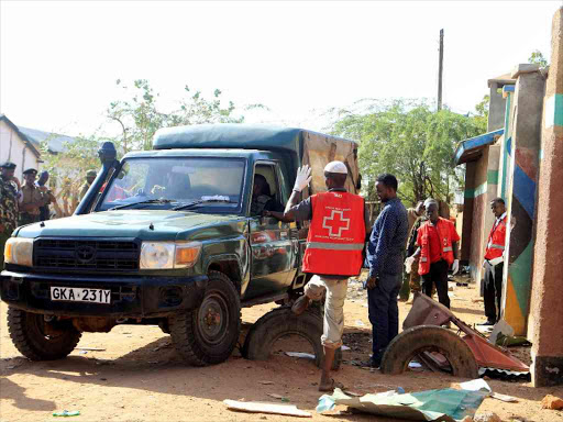 Kenya Red Cross Society workers and police officers stand near the scene of an attack by al Shabaab militants at Bishaere lodging in Mandera town, October 25, 2016./REUTERS