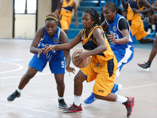 Cynthia Inrankunda (C) of USIU shield from Hellen Oketch (L) of KPA during their of the Kenya Basketball Federation match Finals at Nyayo Stadium Gymnasium in Nairobi on February, 7 2016. USIU won 66-62. Photo/Fredrick Onyango/www.pic-centre.com (KENYA).