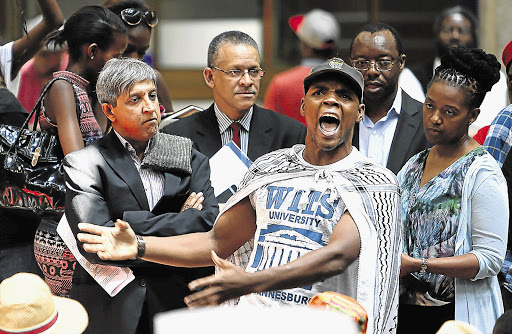 SA Students Congress president Mcebo Freedom Dlamini shouts out to fellow protesters at Wits University yesterday, while vice-chancellor Adam Habib, left, looks on. Sasco claimed the university was not registering students whose fees are to be paid by the National Student Financial Aid Scheme. Wits denied this. File photo