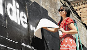 Candy Chang stencils the first Before I Die wall in New Orleans last year. The idea was devised to encourage people to challenge themselves to do things they had maybe thought about but never attempted to accomplish. The messages are recorded as an incentive for participants to help them accomplish their stated goals