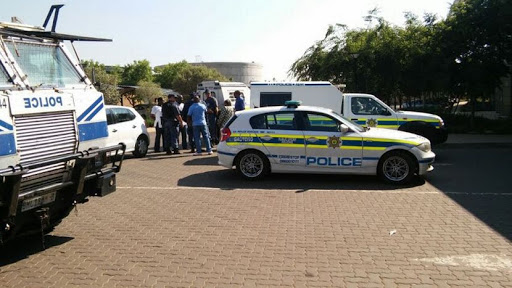 Police guard he van in which three security guards are kept after they were arrested this morning at the Thelle Mogoerane Hospital in Vosloorus.