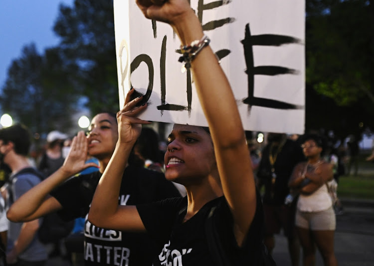 People yell at a line of police officers during a protest outside the Kenosha County Courthouse after a Black man, identified as Jacob Blake, was shot several times by police in Kenosha, Wisconsin, U.S.