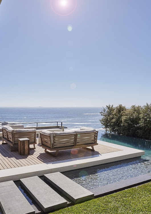 The L-shaped rim-flow pool creates a seamless connection between the garden and the ocean beyond.