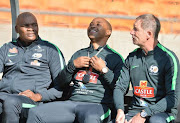 Bafana Bafana head coach Stuart Baxter (R) shares a light moment with his assistants Thabo Senong (M) and Molefi Ntseki (L) during the South African national men's soccer team training session at FNB Stadium on June 06, 2017 in Johannesburg, South Africa.