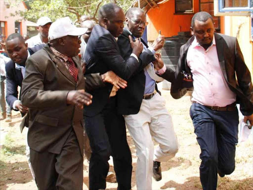 ODM executive director Oduor Ongwen scampers for safety with the help of his bodyguards during violence that rocked an ODM rally in Migori./COURTESY