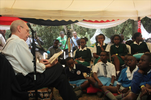 STORY TIME: US Ambassador Robert Godec reads a book at the 2015 Story Moja Festival in Nairobi yesterday. Photo/Enos Teche