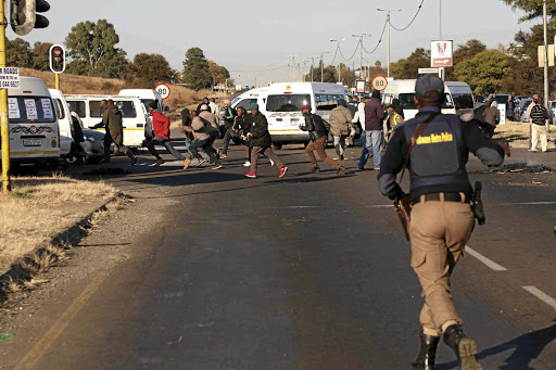 Taxi drivers flee as the Tshwane Metro Police, the SAPS and SANDF soldiers acted on the drivers who had blockaded the R55 in Laudium, Pretoria, yesterday, preventing people from going to work during a strike over government relief fund./Thuulani Mbele