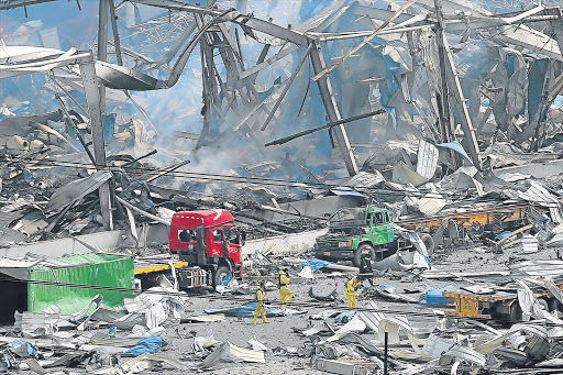AFTERMATH: Rescuers search among the debris yesterday after two explosion rocked Tianjin, China on Tuesday, killing at least 50 people Picture: EPA