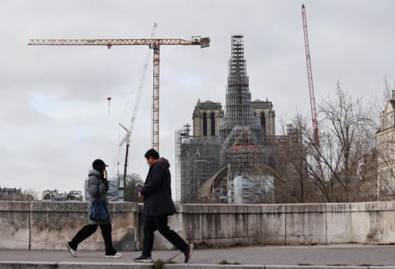 People walk past the Notre Dame Cathedral under renovation in Paris, France, Dec. 8, 2023. (Xinhua/Gao Jing)