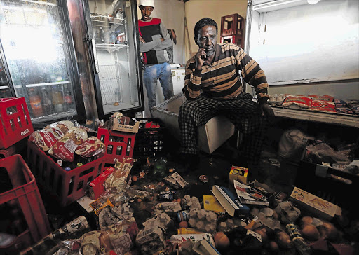 TRASHED: Somali Abdurrahman Mohamed in his looted spaza shop yesterday afternoon
