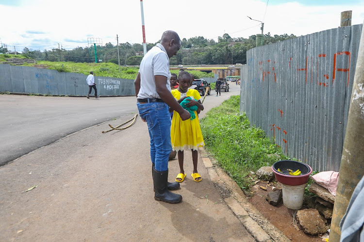 President William Ruto interacts with Nancy, a young student selling bananas by the roadside when he visited Mathare on May 6, 2024.