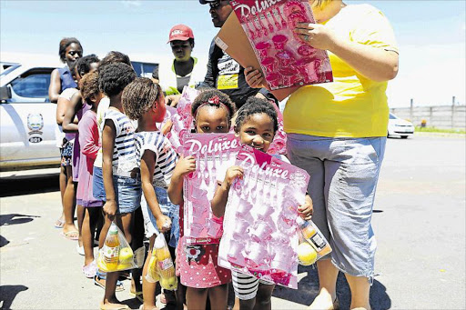 HAPPY SMILES: Lunetha Ngqanya, left, and Mikhulu Poti, 4, with the toys they received from the Motsepe Foundation in Mdantsane yesterday Picture: STEPHANIE LLOYD