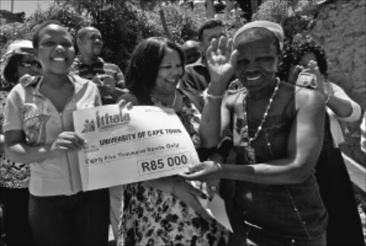EXCITED: Top matriculant Mandisa Nene receives a cheque from Noluthando Mayende-Sibiya while her mother Sibongile looks on. Pic. Thuli Dlamini. 14/01/2010. © Sowetan.