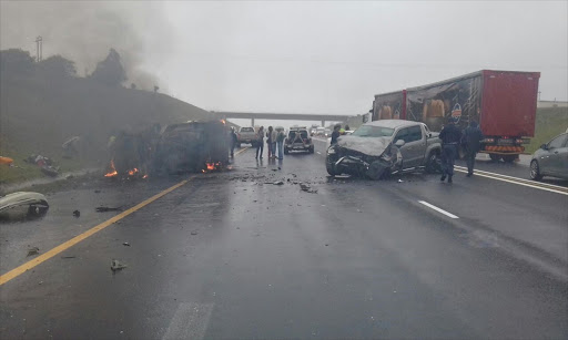 Motorists pull taxi passengers from burning wreckage. Picture Credit: IPSS Medical Rescue