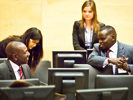 ALREADY IN THE DOCK: Deputy President William Ruto and journalist Joshua arap Sang chat at the ICC. Photo/FILE