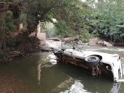A passing motorist is believed to have pulled two men from a car after it plunged into a river near Pretoria on Thursday night. One of the occupants died at the scene.