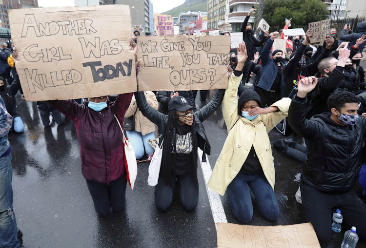 Gender-based violence demonstrators kneel in the street in front of parliament in Cape Town on August 29 2020.