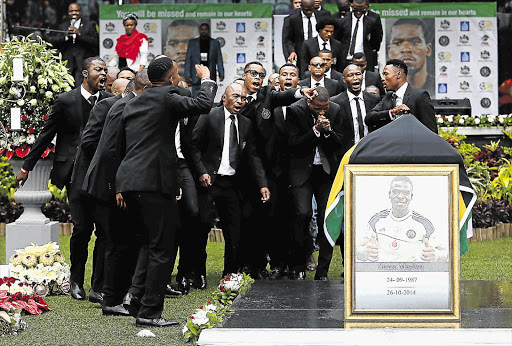 Orlando Pirates team members sing and dance next to the coffin of Senzo Meyiwa at his funeral at Moses Mabhida Stadium, Durban yesterday