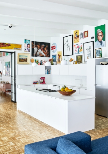 All-white cabinetry fades into the background while creating focus on the colourful objects displayed throughout the space.